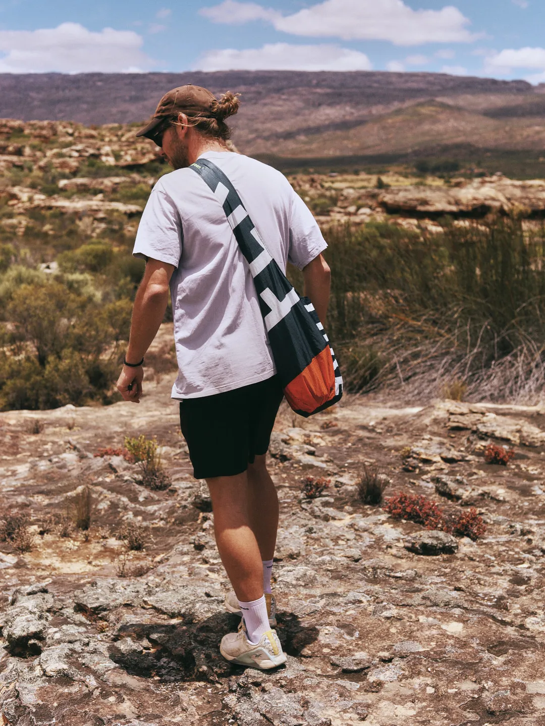 man carrying an orange kite bag through the Cederberg