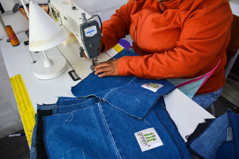 an artisan's hands laying out bright kite sail ready for cutting