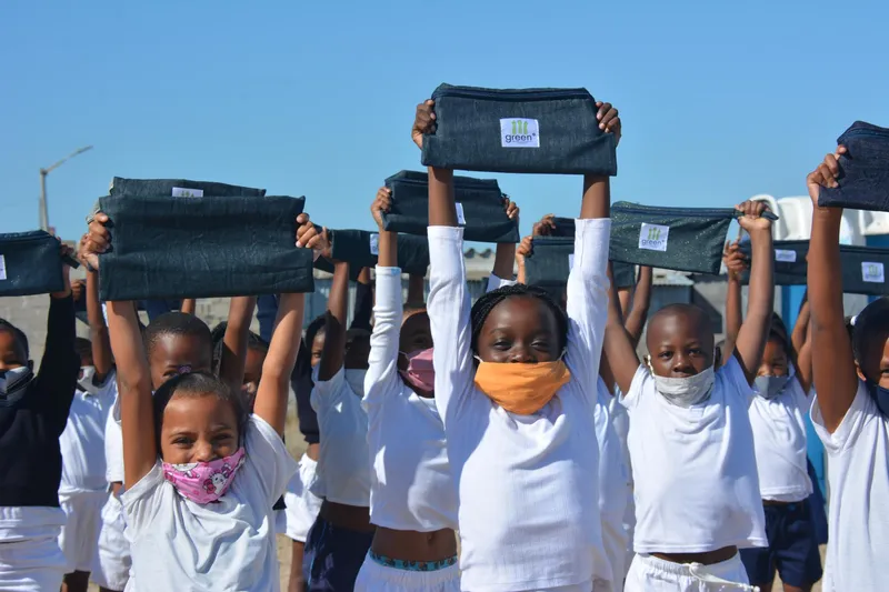 children at a cape flats primary holding up denim pencil cases