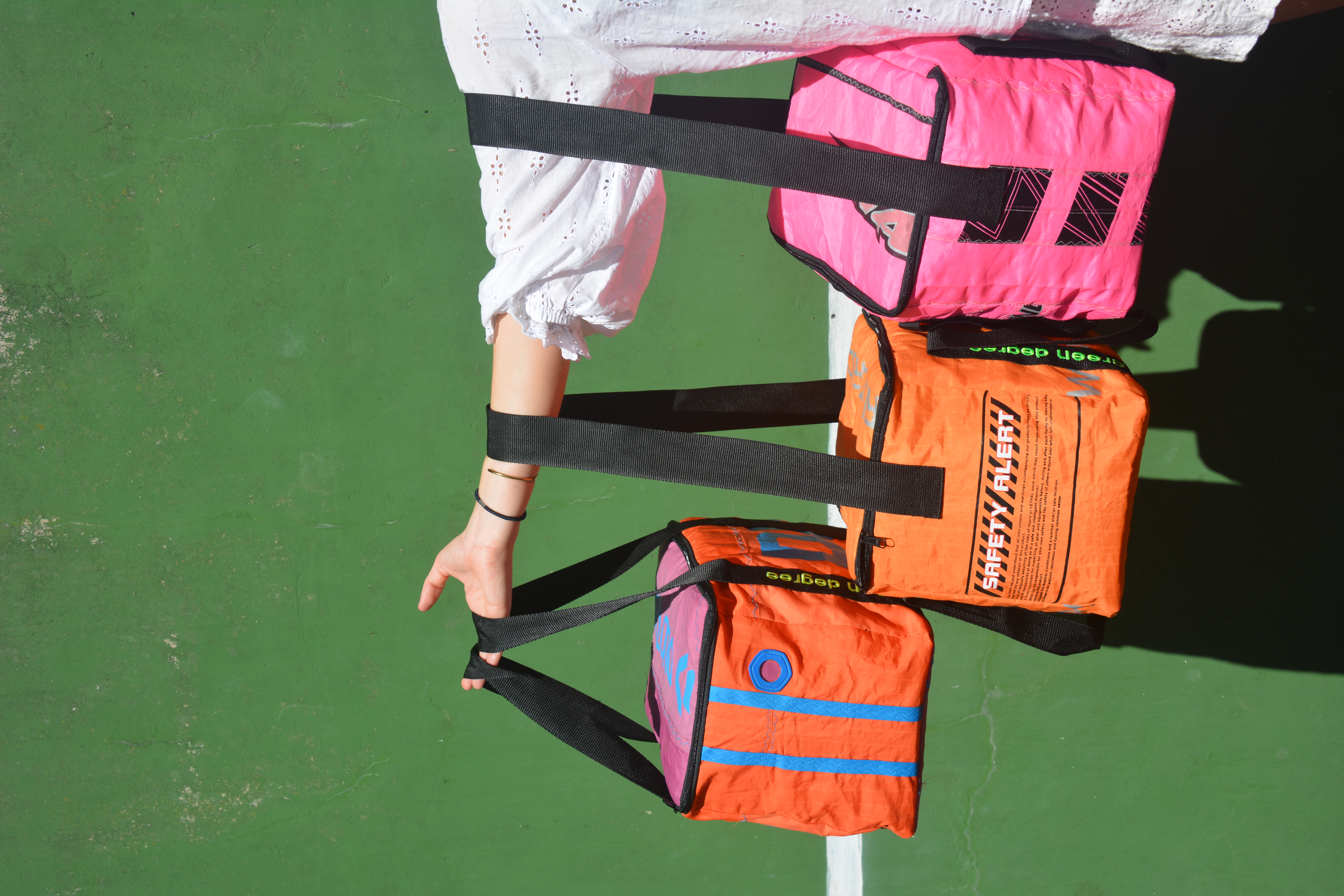 three kite-fabric cooler bags in orange, pink and blue