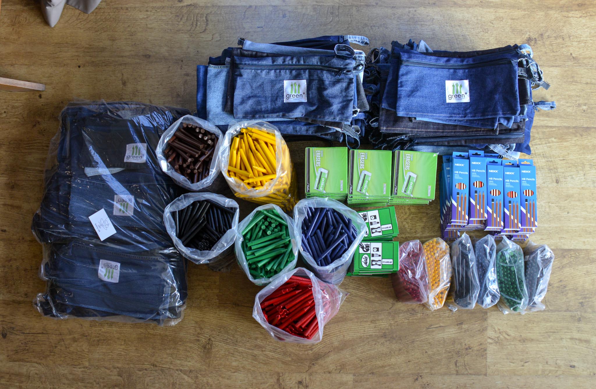 flatlay of denim pencil cases with pencils, erasers and exercise books